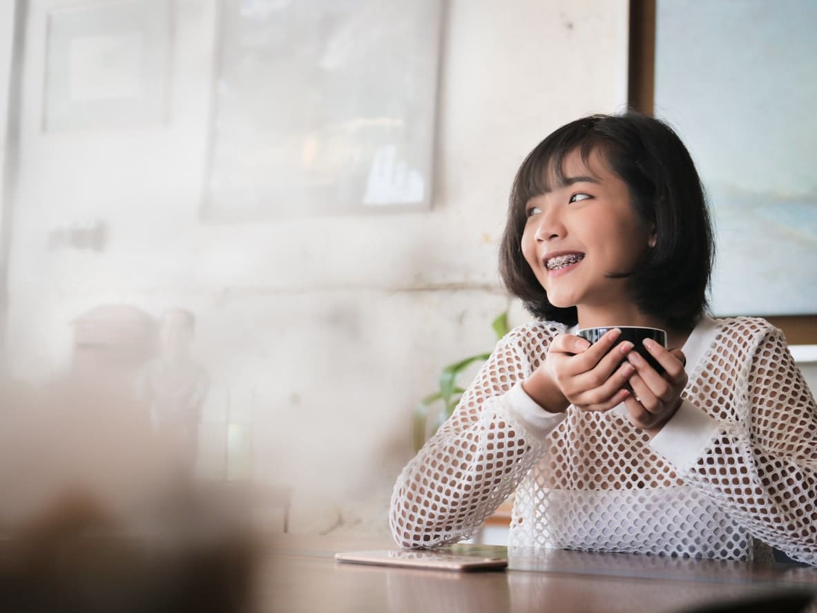 girl with braces on teeth at coffee shop
